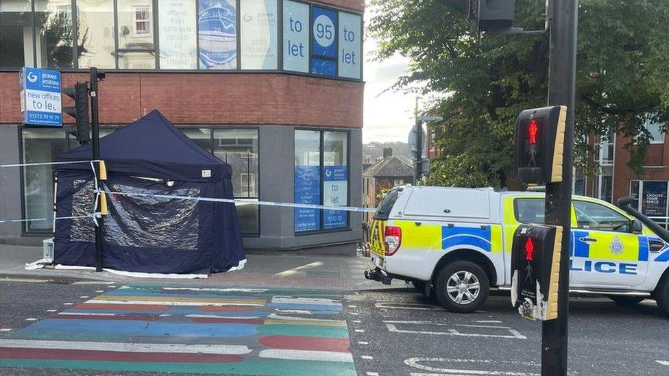 A small, blue marquee and police car on Queen's Road