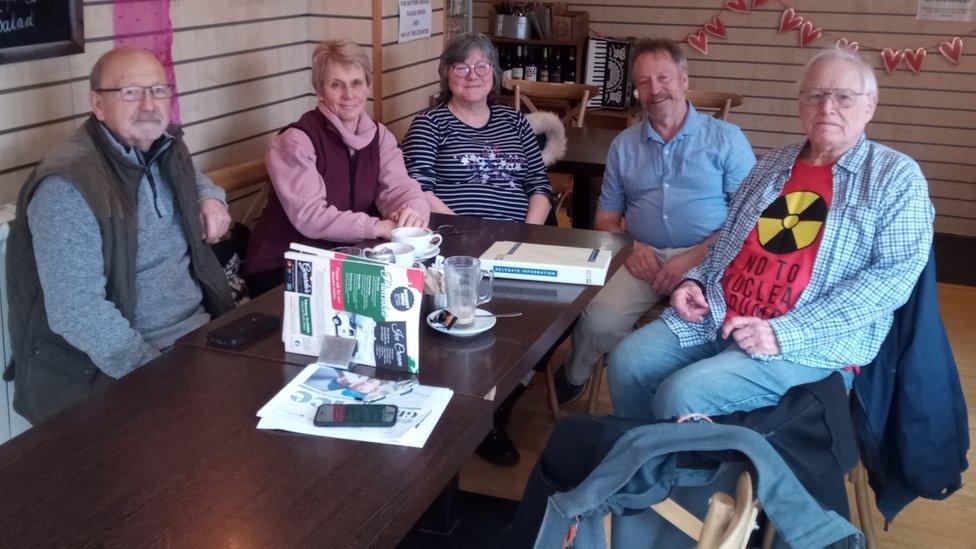 Five people sitting around a table