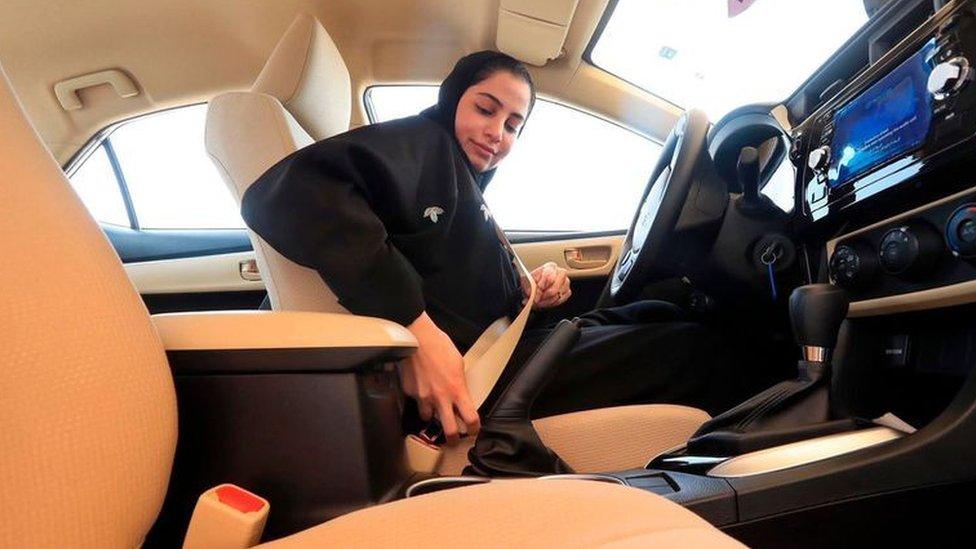 Saudi woman buckling her seatbelt before doing a driving test at the General Department of Traffic