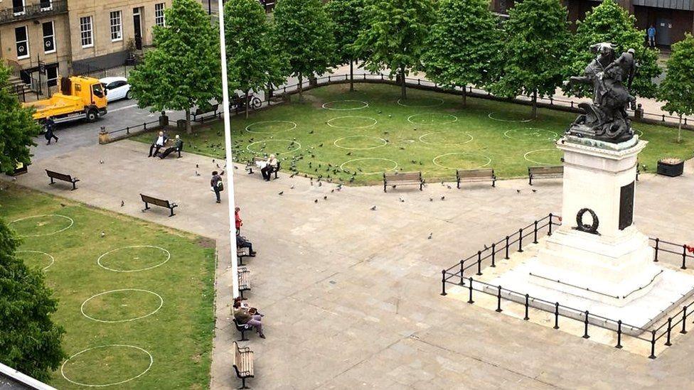 Social distancing circles marked on the grass during the Covid pandemic