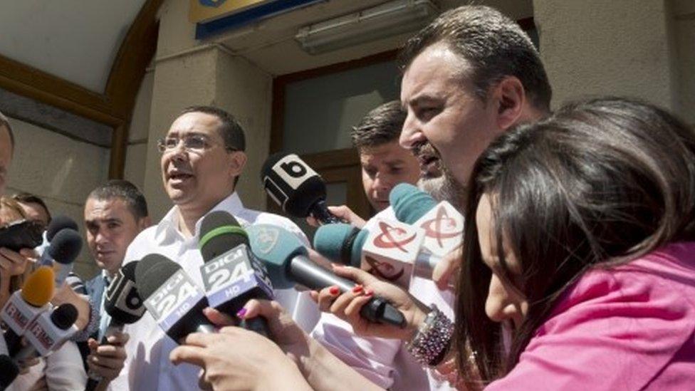 Romanian Premier Victor Ponta is surrounded by media as he exits the national anti-corruption prosecutors office (13 July 2015)