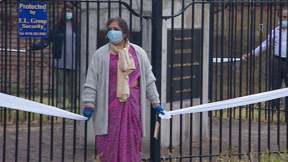 People standing around Gandhi statue