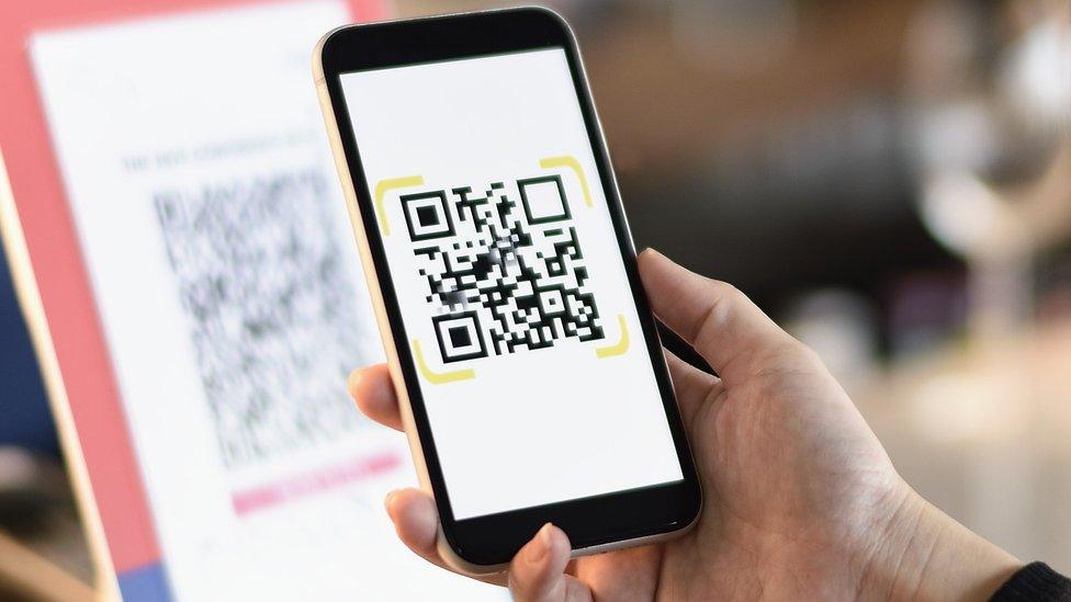 A QR code being scanned on a phone