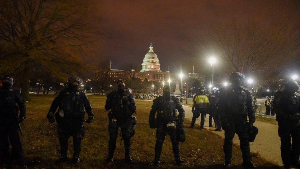 Police stand guard during the curfew overnight on Wednesday