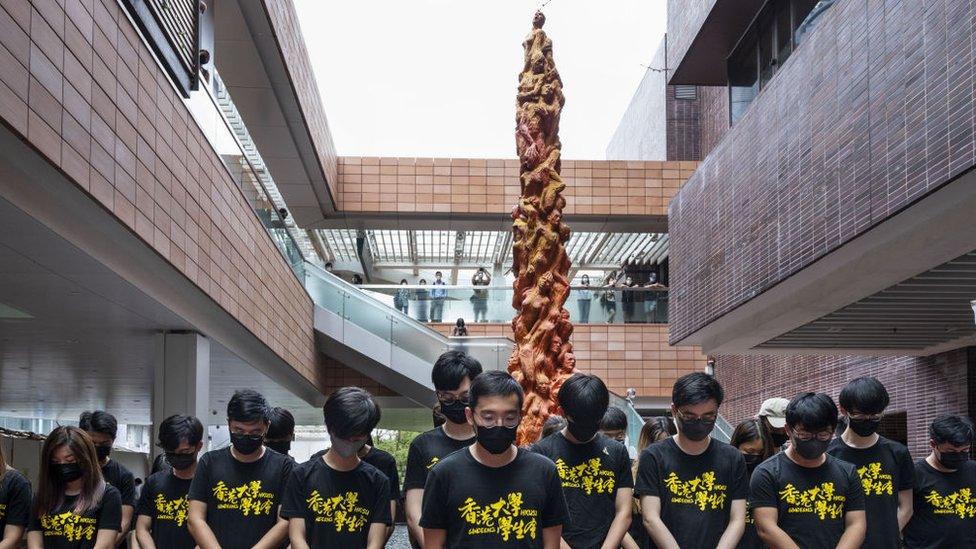 Students hold a minute's silence in front of the statue on 4 June 2021