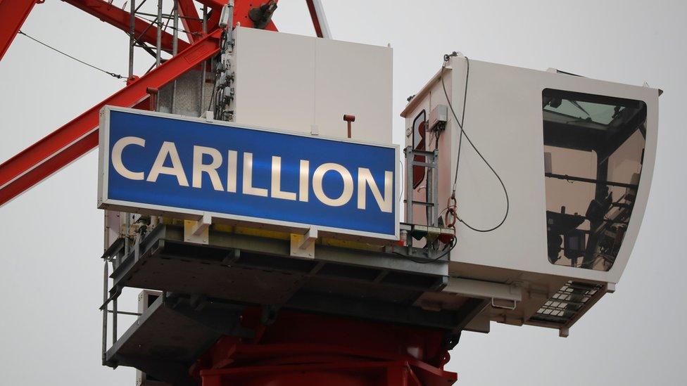 A construction crane showing the Carillion sign