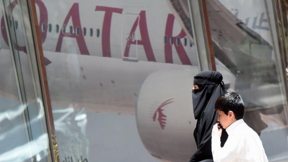 A woman and a boy walk past the Qatar Airways branch in the Saudi capital Riyadh. Photo: 5 June 2017