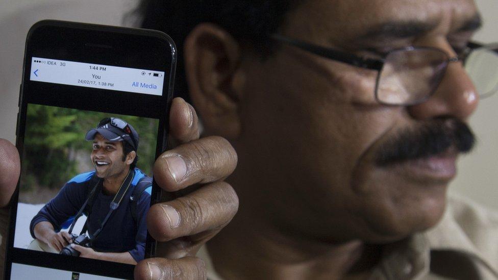 A picture of Alok Madasani is shown on a mobile phone as his father, Jaganmohan Reddy, talks to the media in Hyderabad, India, Friday, Feb. 24, 2017