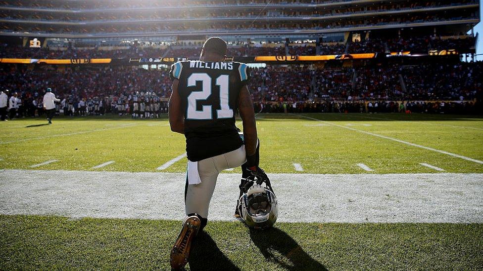 Teddy Williams of the Carolina Panthers kneels