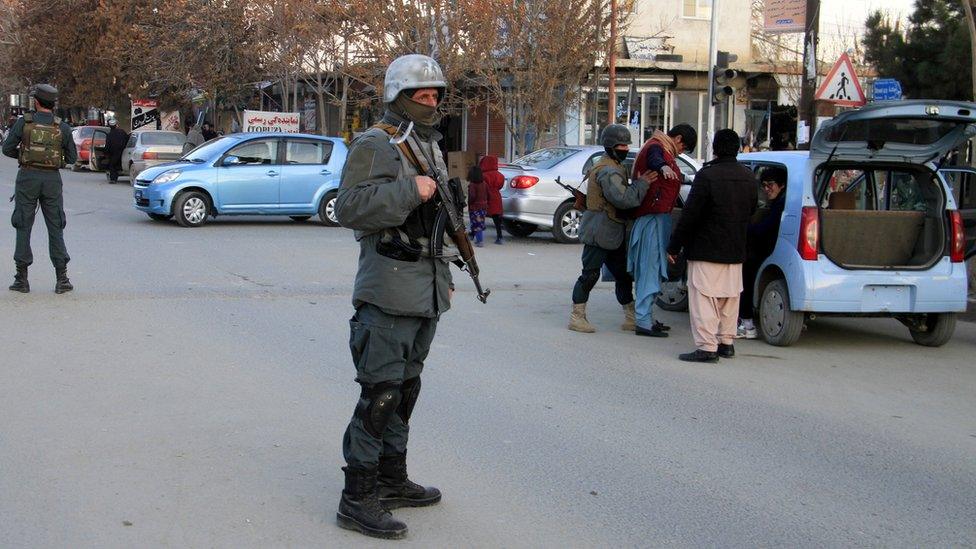 Afghan security officials check vehicles on a road side check point on the outskirts of Ghazni, Afghanistan, 18 December 2020