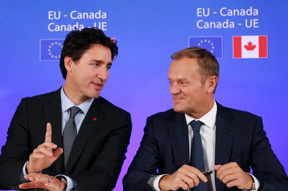 Canadian Prime Minister Justin Trudeau (L) talks to European Council President Donald Tusk (R) during Ceta signing, 30 Oct 16