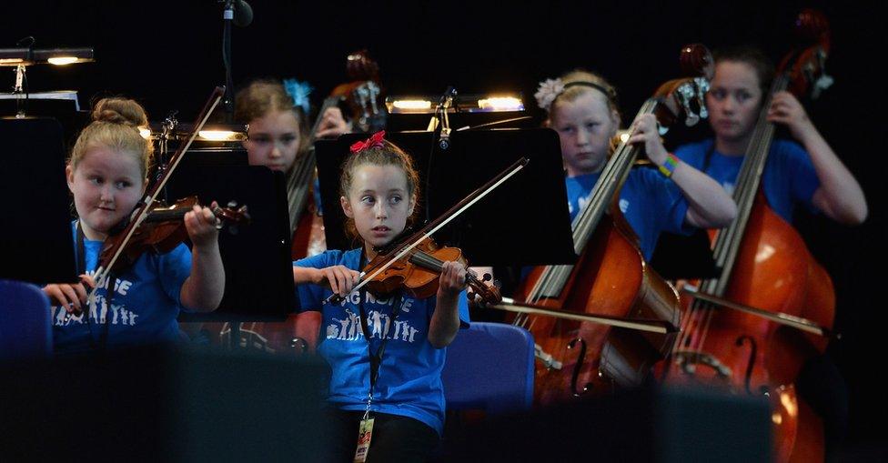 Children from the Raploch estate Big Noise orchestra play at The Big Concert on 21 June 2012 in Stirling, Scotland