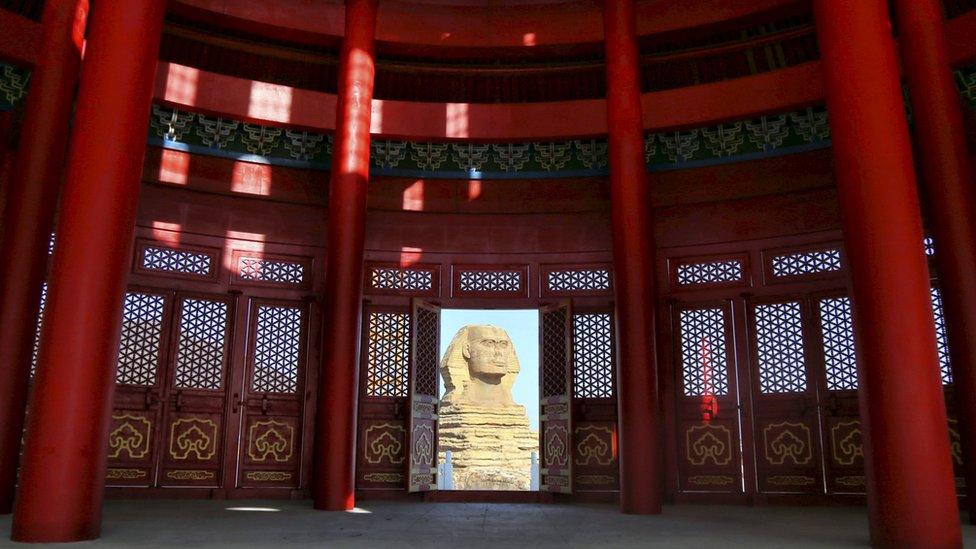 A replica sphinx seen through the hybrid building's door