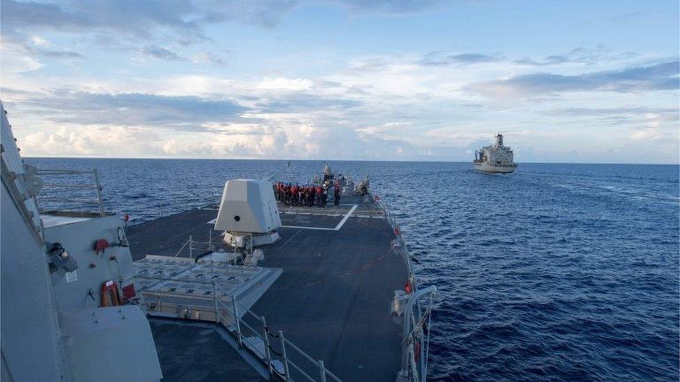 This handout photo taken on May 19, 2017 and received from the US Navy on May 25, 2017 shows the Arleigh Burke-class guided-missile destroyer USS Dewey (L) preparing for a replenishment-at-sea with the Henry J. Kaiser-class fleet replenishment oiler USNS Pecos (R) in the South China Sea.