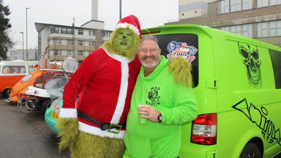 Grinch and a men next to a VW van