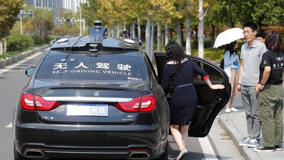 A woman test drives a self-driving vehicle developed by Nanjing-based autonomous driving company AllRide.ai