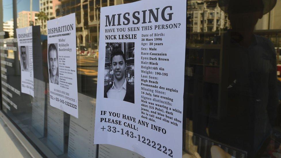 A man looks at missing person notice in Nice with picture of Nicolas Leslie on 16 July