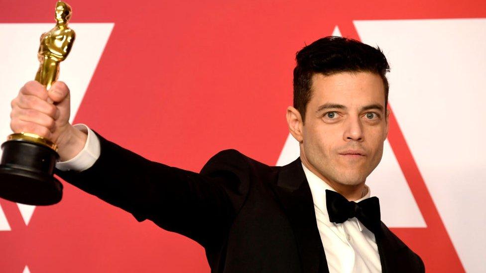 Rami Malek holding up his Oscar