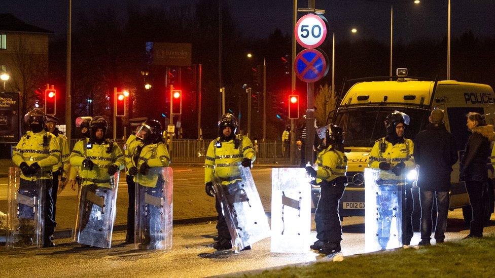 Police in riot gear after a demonstration outside the Suites Hotel in Knowsley