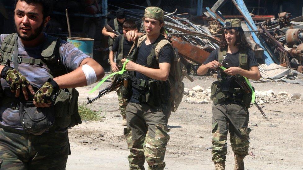 Free Syrian Army fighters walk with their weapons in Ramousah area southwest of Aleppo