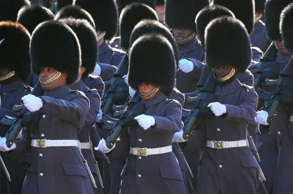 Members of the King's Guard march past Buckingham Palace ahead of the State Opening of Parliament on November 7, 2023 in London, England.