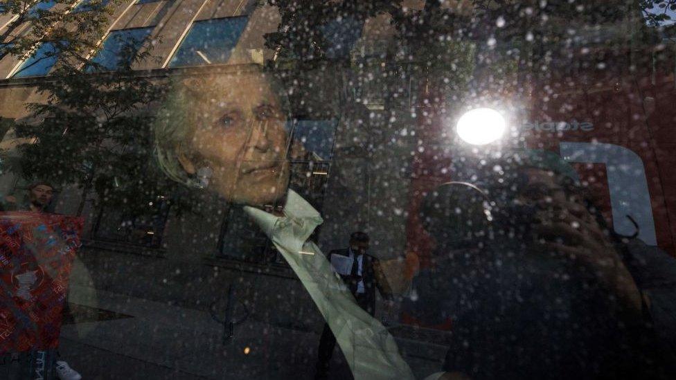 Seen through a police vehicle window, Canadian-Finnish fashion mogul Peter Nygard leaves a courthouse in Toronto, Ontario, on September 26, 2023.