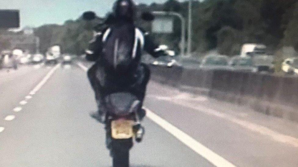 Biker performing wheelies on M6