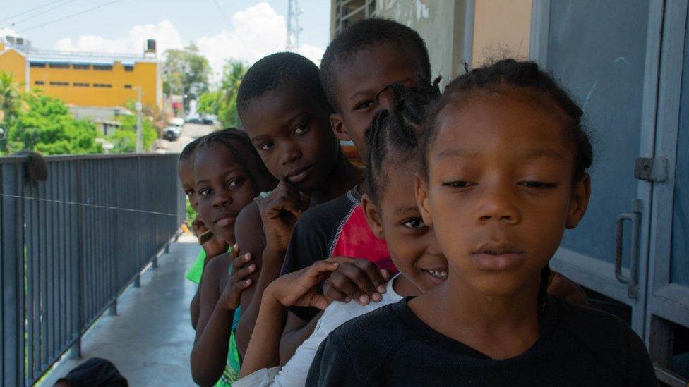 Children line up to play in a school that has become a shelter for displaced people amid the gang-related violence that has wracked the country, in Port-au-Prince on 22 April 2024