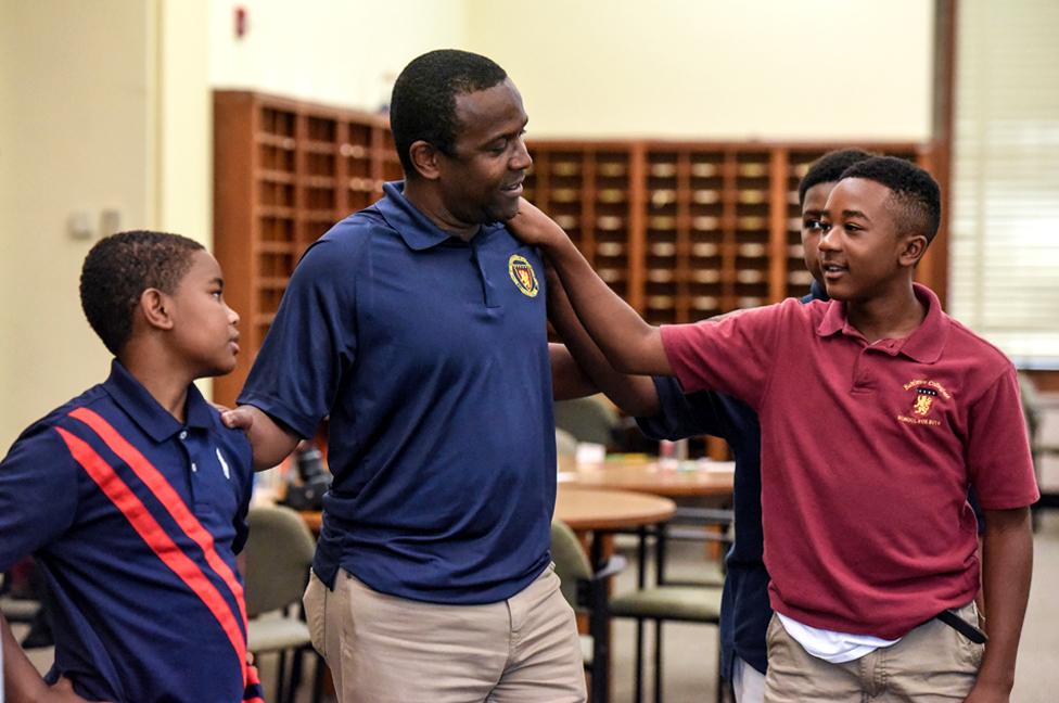 Edwin Avent participates with students in a learning exercise at a summer session of a charter school called Baltimore Collegiate School for Boys