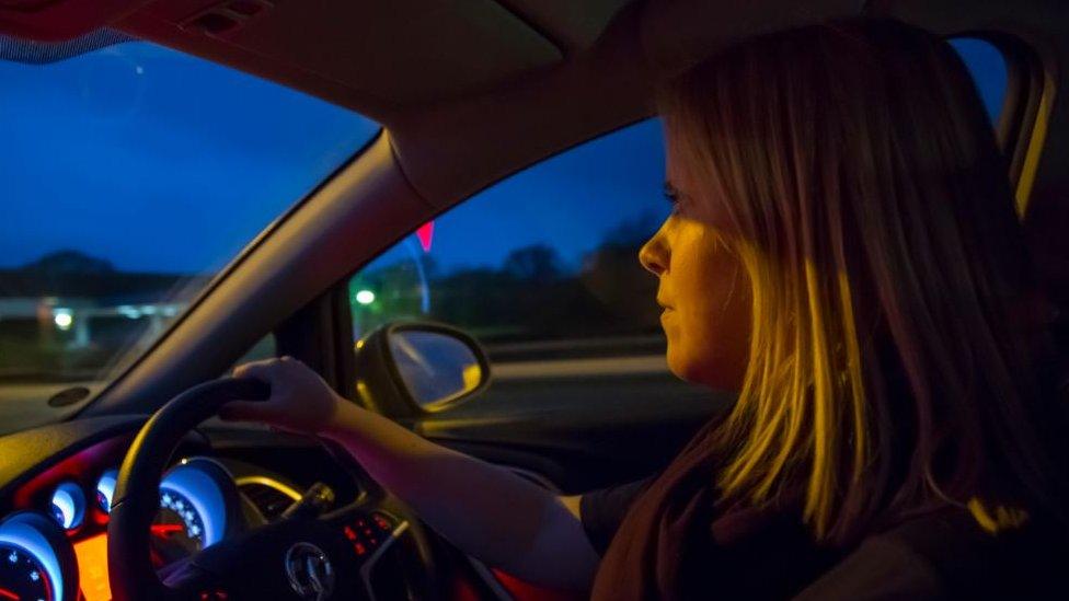 A woman driving at night