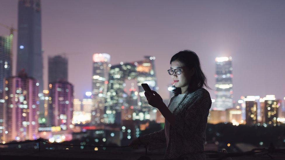 A Chinese woman using her phone