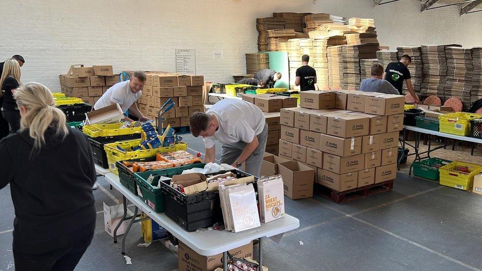 Volunteers packing boxes of food