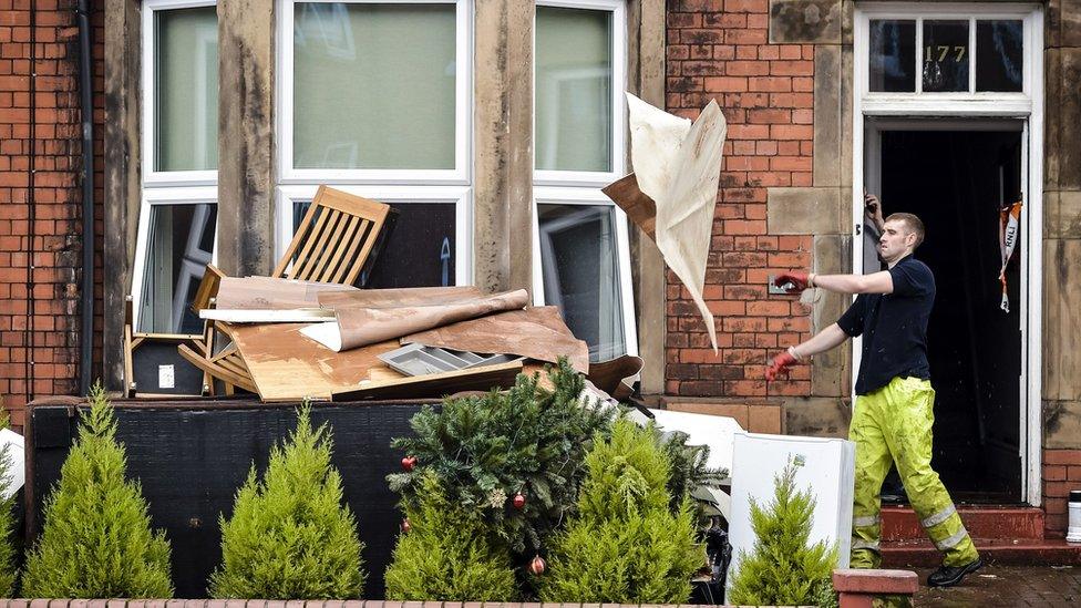 Workman cleaning up flooded house in Carlisle