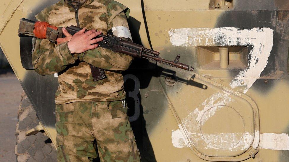 A Russian soldier standing next to a pro-Russian Z symbol