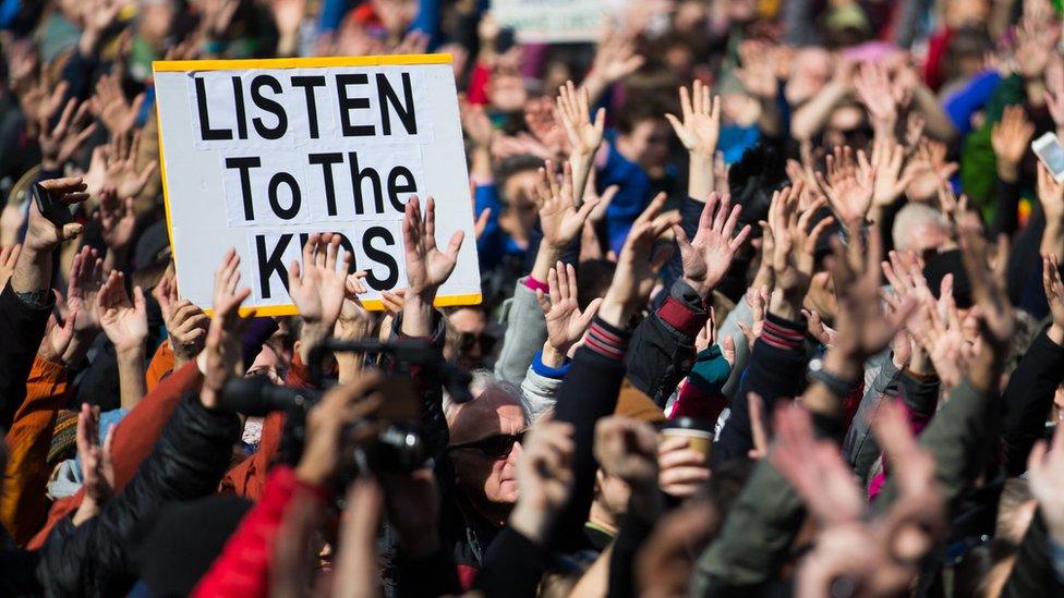 People hold their hands up as directed by musician Brandi Carlile at Seattle Center during the March for Our Lives rally