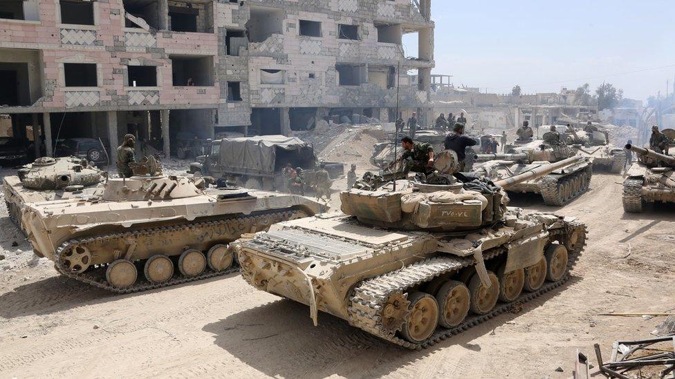 A picture taken on April 8 2018 shows Syrian Army soldiers gathering in an area on the eastern outskirts of Douma