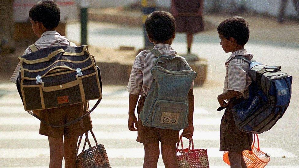 School children in India carrying large backpacks