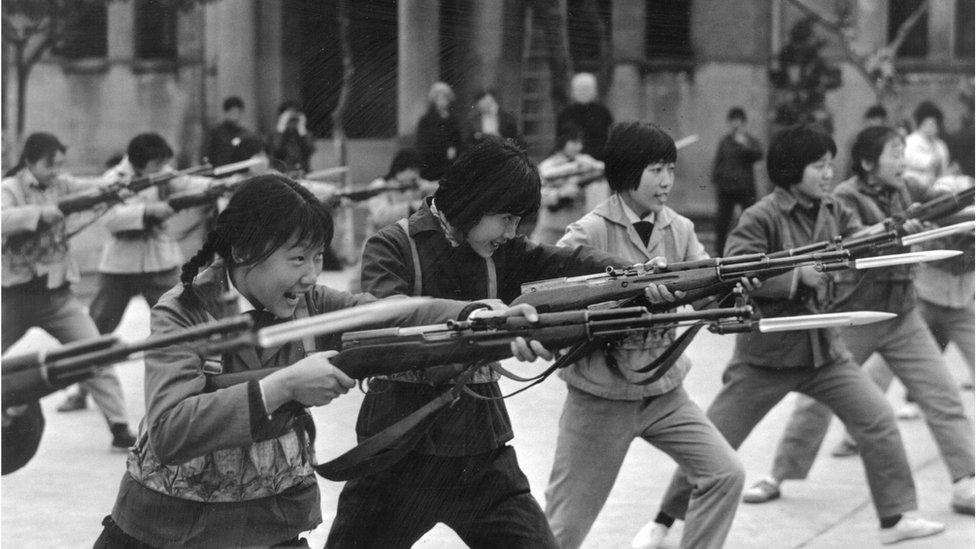 Rows of young girls from the Little Red Guards in Shanghai, practice their bayonet drill on 1 May 1973