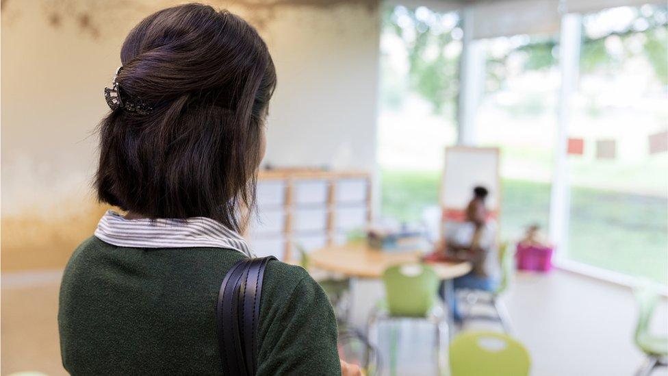 A teacher watches over a classroom