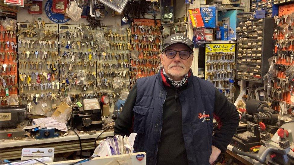 Colin Watkins standing in his locksmiths in Cinderford surrounded by keys on the walls