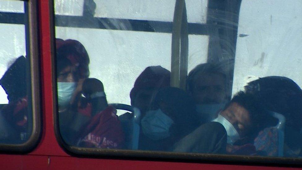 Migrants asleep on board double decker bus at a Kent processing centre