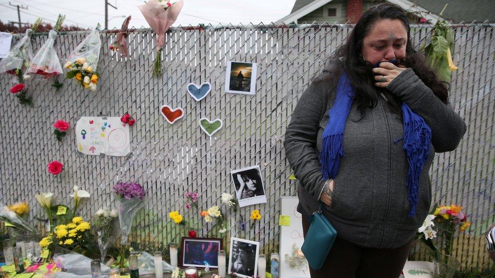 A mourner cries at a memorial near the burned warehouse in December 2016