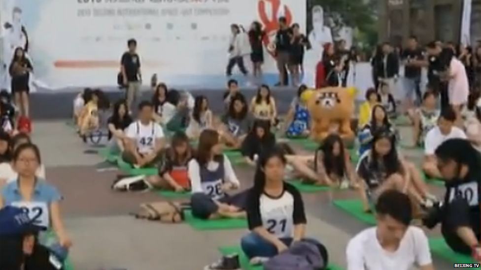 Contestants sitting on floor mats during the competition