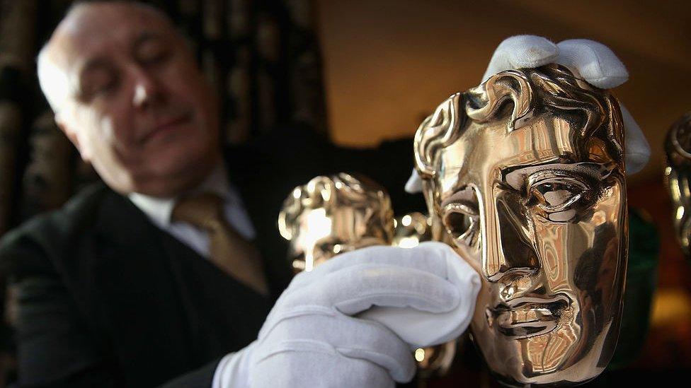 man cleaning bafta award