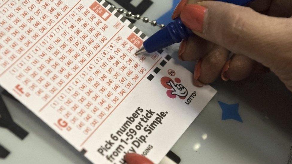 Person fills out National Lottery ticket