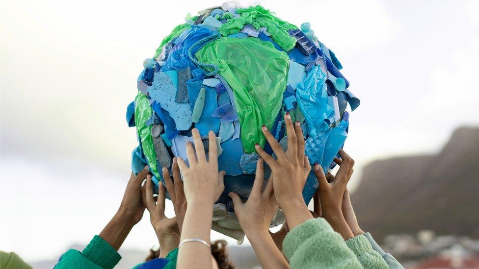 Hands holding up a globe made of plastic