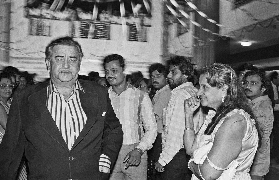 Actor Raj Kapoor at the premiere of Janbaaz while a fan gazes at him, 1986