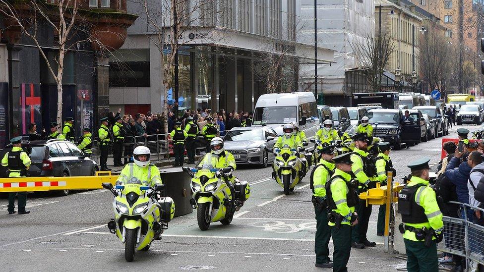 Police officers on motorcycles lead the presidential motorcade