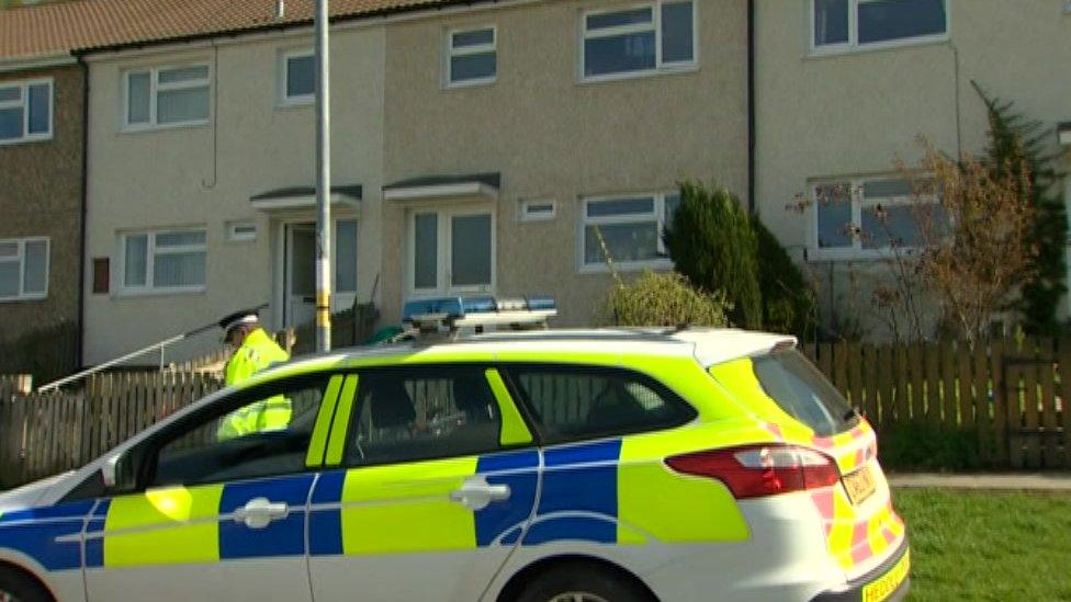 Police car and officer outside houses on the Glyndwr estate in Knighton, Powys, following the suspected murder of Hollie Kerrell, 28