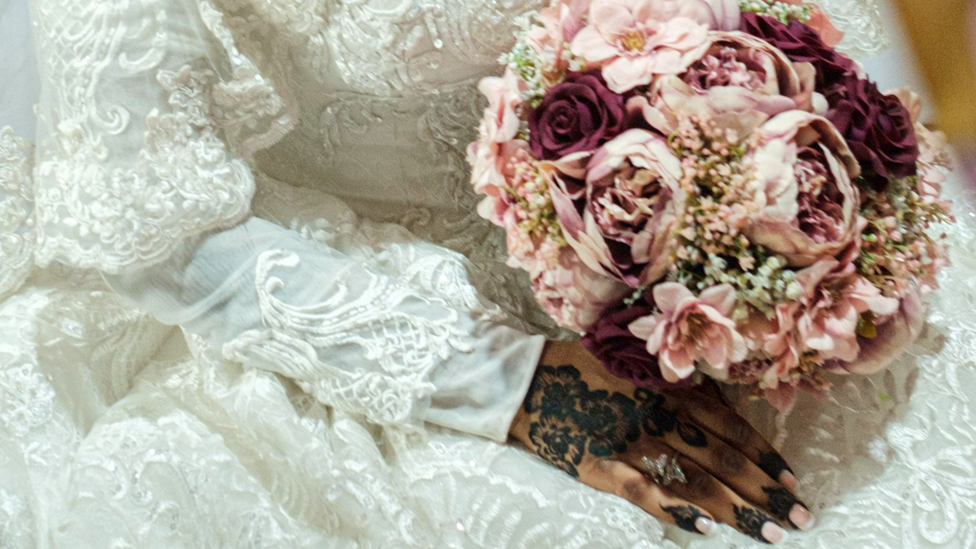 A bride in Sudan holding a bouquet of flowers